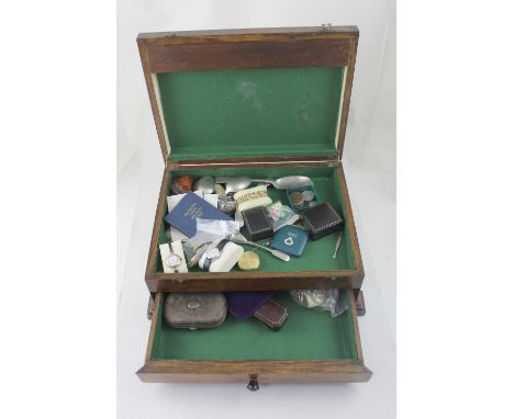 A wooden box containing various costume jewellery and curios to include spoons, fashion watches, pocket watch, medal, coins, 