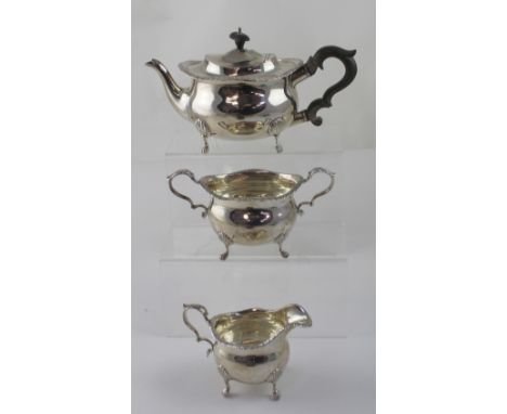 An Elizabeth II hallmarked silver three-piece tea service of baluster form, comprising teapot with wooden handle, twin-handle