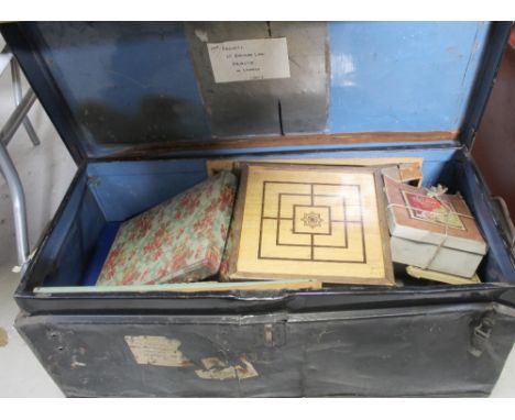 A metal trunk containing a collection of vintage games and toys.