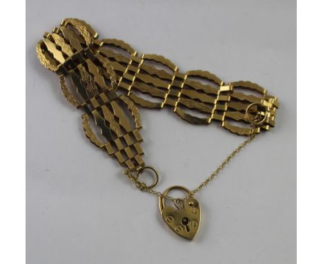 A 9ct yellow gold gate bracelet with heart-shaped clasp and safety chain, approx 11g.