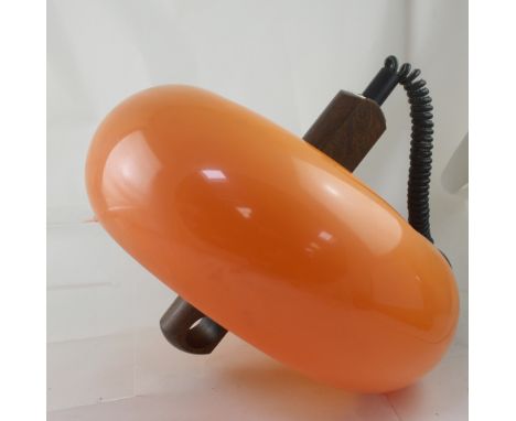 A c1970s orange plastic and oak retractable ceiling light, the shade of cheese wheel form is mounted on an oak column with tw