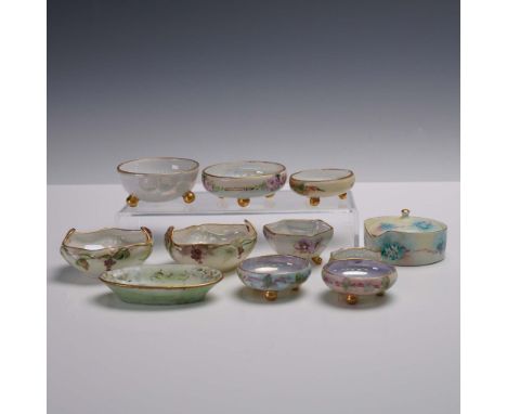 An assorted collection of 11 hand painted porcelain salt cellars and condiment bowls, each featuring floral motifs and delica