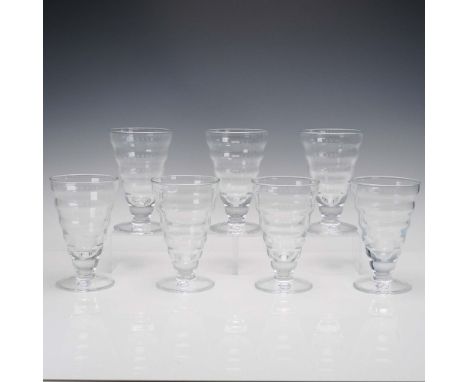 A set of seven tall footed tumblers by Vietri a brand recognized for its Italian craftsmanship and refined aesthetic. Each gl