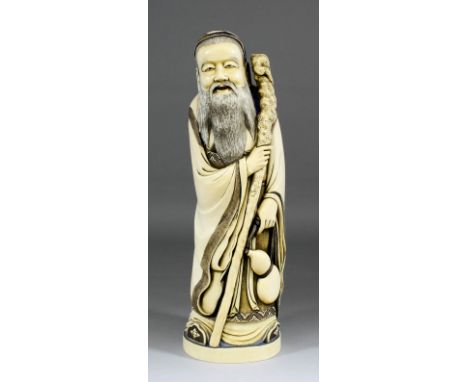 A Chinese carved ivory tusk figure of a standing Sage holding a staff and flask, 16ins (407mm) high (red seal mark to base - 