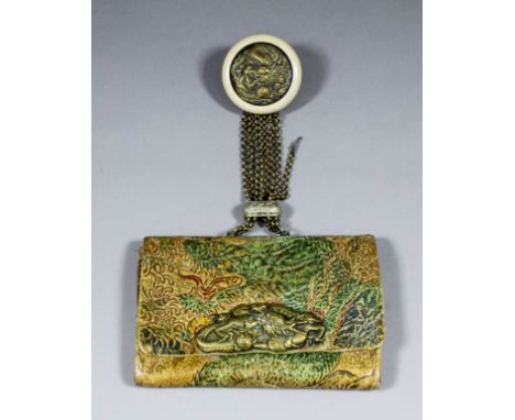 A Japanese Kagamibuta netsuke of a dragon chasing the Sacred Pearl, with celluloid bowl attached to a Japanese leather tobacc