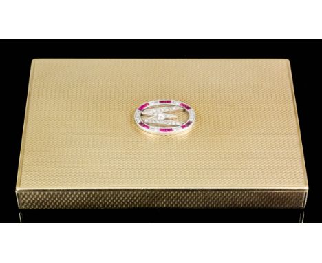A George V lady's 9ct gold ruby and diamond set compact with engine turned decoration and set with a diamond "W" within an ov