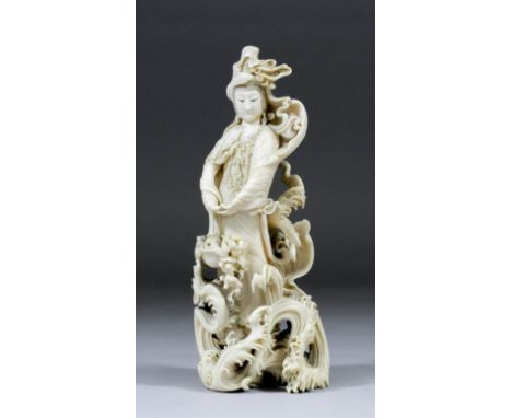 A Japanese carved ivory okimono of a female figure with basket, standing amongst turbulent waves and a strong wind blowing he