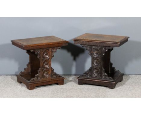 A pair of oak rectangular low occasional tables with moulded edge to top, the shaped supports carved with three circa paterae