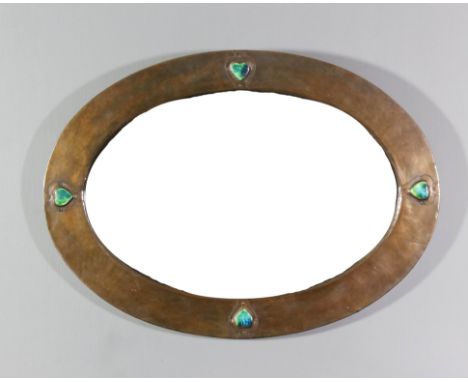 An early 20th Century English hammered copper on wood oval wall mirror in the "Liberty" manner, mounted with four raised enam