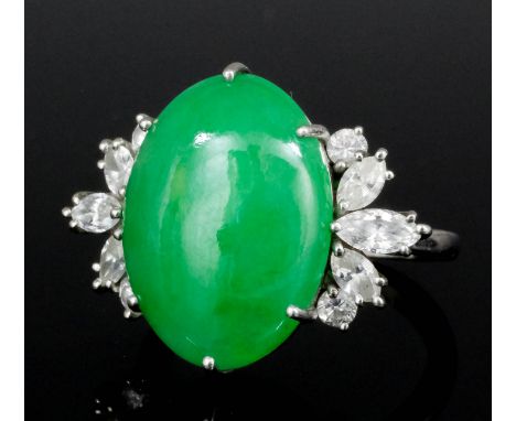 A 1980's platinum mounted jade and diamond ring retailed by Asprey, the oval jade cabochon 19mm x 13mm overall, bordered to e