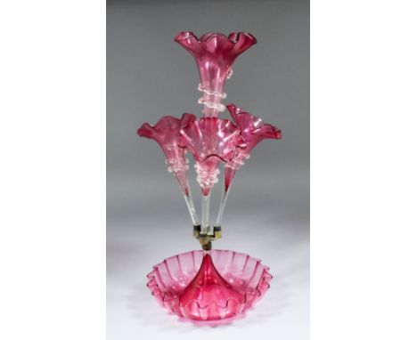 A Victorian cranberry glass epergne or table centre with central trumpet shaped vase and  three smaller vases all with crimpe