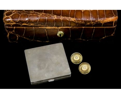 An early 20th Century brown crocodile leather covered jewellery box, 40mm x 60mm x 20mm deep, containing a pair of gold colou