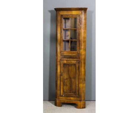 A walnut two tier corner cupboard of 18th Century design, the whole of small proportions, the upper part with angled cornice,