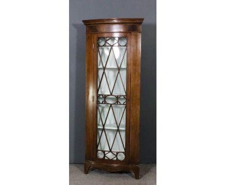 A mahogany corner cupboard of Georgian design with slight bow front, moulded cornice, the painted interior fitted three shelv