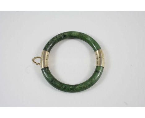 A MOTTLED GREEN JADE BANGLE 8cm. dia.