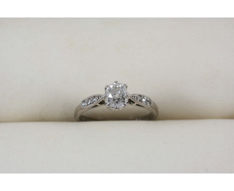 A DIAMOND SOLITAIRE RING the cushion-shaped diamond is set with three single-cut diamonds to each shoulder, in 18ct. white go