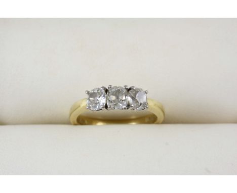 A DIAMOND THREE STONE RING the three cushion-shaped diamonds are set in 18ct. gold. Size M.