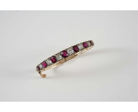 A VICTORIAN RUBY AND DIAMOND HALF HINGED BANGLE set to one side with alternate oval-shaped rubies and cushion-shaped diamonds