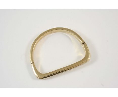 A YELLOW AND WHITE GOLD HALF HINGED BANGLE of stirrup form, 27 grams.