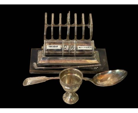 Silver golf theme desk perpetual calendar, silver seven bar toast rack, silver egg cup and George IV tablespoon (4).