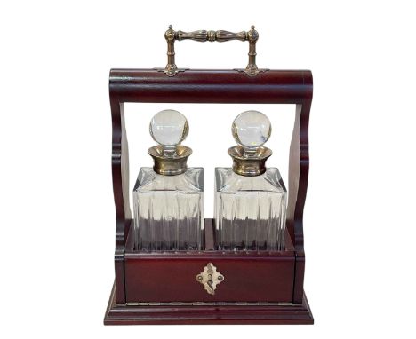 Mahogany tantalus and two silver collared decanters.