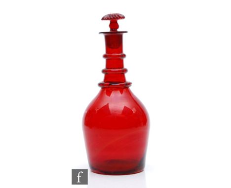 An early 19th Century decanter of shouldered ovoid form with a three ring neck and mushroom form stopper, all in deep ruby, h