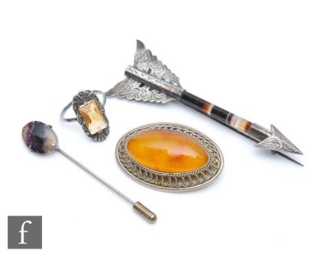 A Victorian Scottish banded agate and white metal arrow brooch, the faceted stem with white metal mounts, the feathers chased