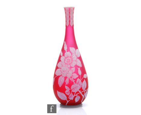 A late 19th Century Thomas Webb &amp; Sons cameo glass vase of footed slender bottle form, cased in opal over ruby and cut wi