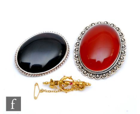 Two oval 925 silver brooches, the first set with an amber coloured agate and the second with an obsidian, largest 4.8cm x 3.9