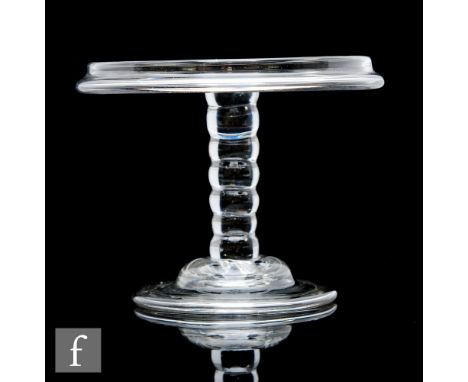 An 18th Century glass patch stand circa 1740, the circular top with a vertical rim, raised to a six section bobbin stem and d