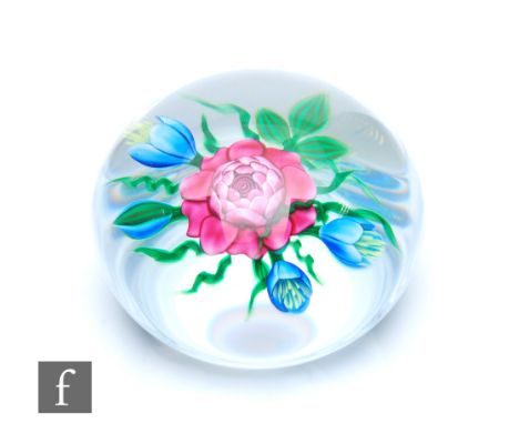 A later 20th Century Ken Rosenfeld glass paperweight of domed form, internally decorated with three lampwork blue flowers aro