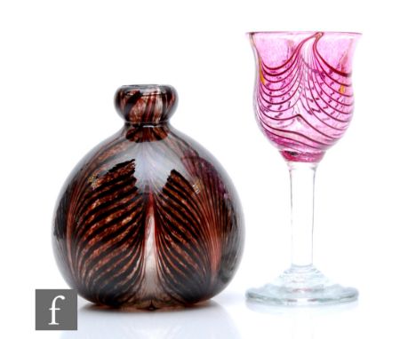 A later 20th Century George Elliot Studio glass goblet, the tulip bowl decorated with deep ruby pulled threads over a mottle 