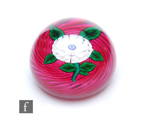 A contemporary John Deacons glass paperweight, of domed form internally decorated with a large opal pom pom dahlia with a cen