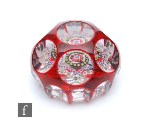 A Baccarat glass overlay paperweight internally decorated with a central complex cane in white and blue surrounded by a ring 