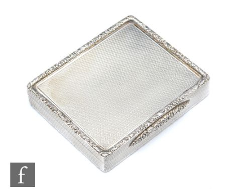 A hallmarked silver square snuff box with engine turned decoration to whole, floral raised border and thumb piece, weight 134
