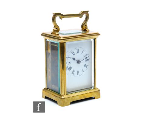 A 20th Century brass carriage clock, Roman numerals to a white enamelled dial below carrying handle, height 15cm. 
