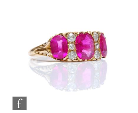 An early 20th Century 18ct ruby and diamond nine stone ring, three central rubies, largest approximately 1.10ct, spaced by tw