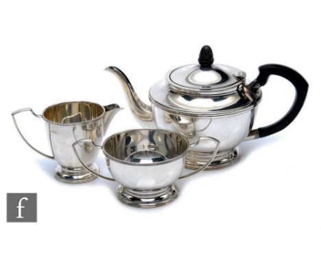 A hallmarked silver three piece tea set each with a circular stepped foot below plain bodies, pot terminating in acorn finial