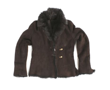 A Celt sheepskin coat. With a dark brown exterior and interior, the two buttons modelled as ceramic dogs. Size 40This lot is 