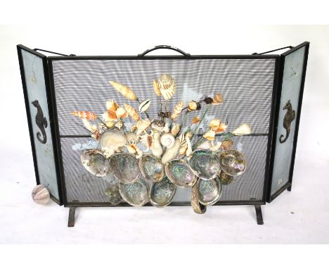 A mid-century wrought iron folding fire screen. Guard later decorated with mixed seashells. L123cm x D20cm x H75cm