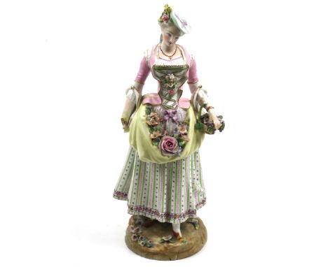 A ceramic figure of a lady, with a Meissen mark to the underside. The woman is dressed in 19th century costume and holding a 