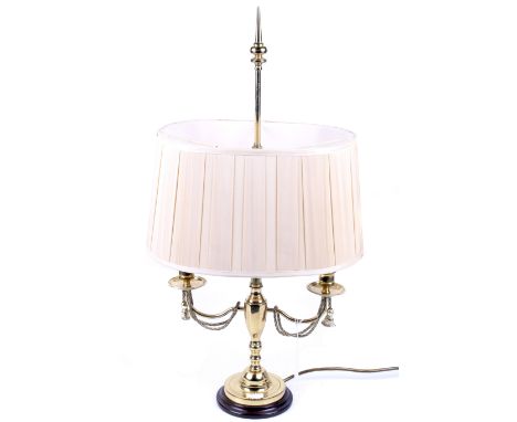 A 20th century brass two-light candelabra table lamp. Mounted on a circular base, with a cream shade, H72 cm 