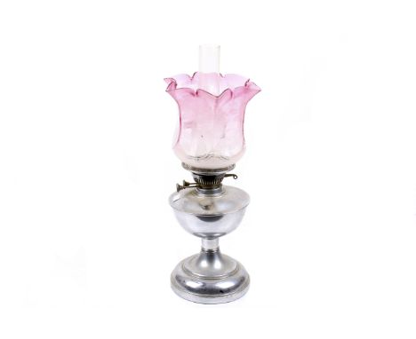 A 20th century oil lamp and shade. The glass shade coloured in a graduating cranberry hue and decorated with etched roses, H4