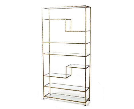 A continental gilt metal freestanding shelf. Hammered metal finish and glass shelves. L101cm x D33cm x H210cm