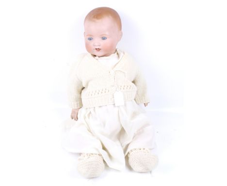 A vintage 'A M' Armand Marseille bisque head baby doll. With sleepy blue glass eyes, open mouth showing two bottom teeth, com