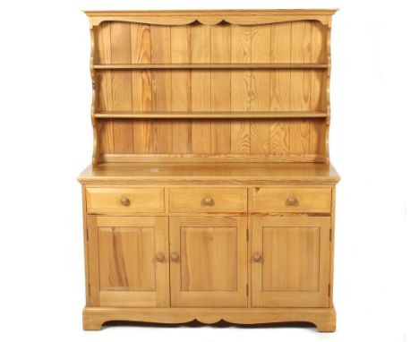 A contemporary pine dresser. The upper section with two shelves, the base with three drawers over three panelled cupboard doo