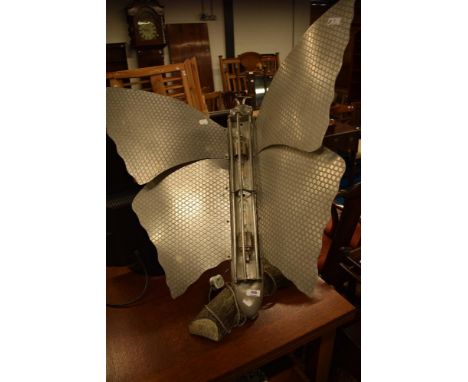 An Art Deco Butterfly form room heater converted into a lamp, in aluminium on a swivel arm branch on naturalistic log base. 3