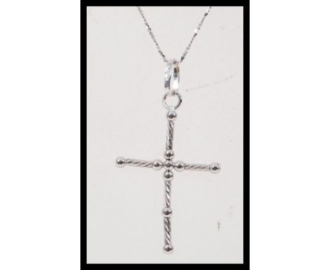 A stamped 750 white gold necklace having a crucifix pendant on a fine twisted chain. Chain measures 18 inches. Total weight 2