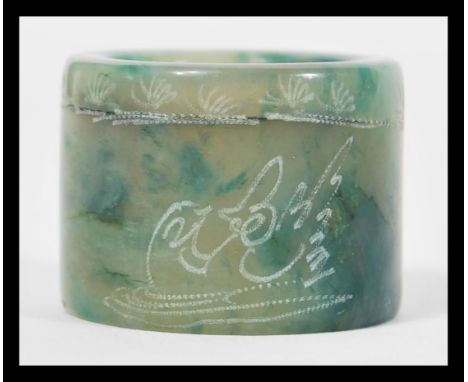 A Chinese green jade archer ring of typical form being signed to side.