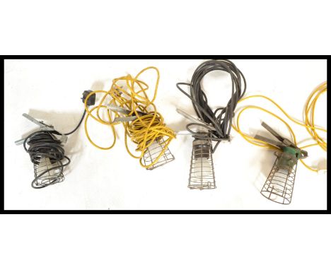 A group of four vintage retro 20th Century inspection lamps having wire cages and clamp mounts.